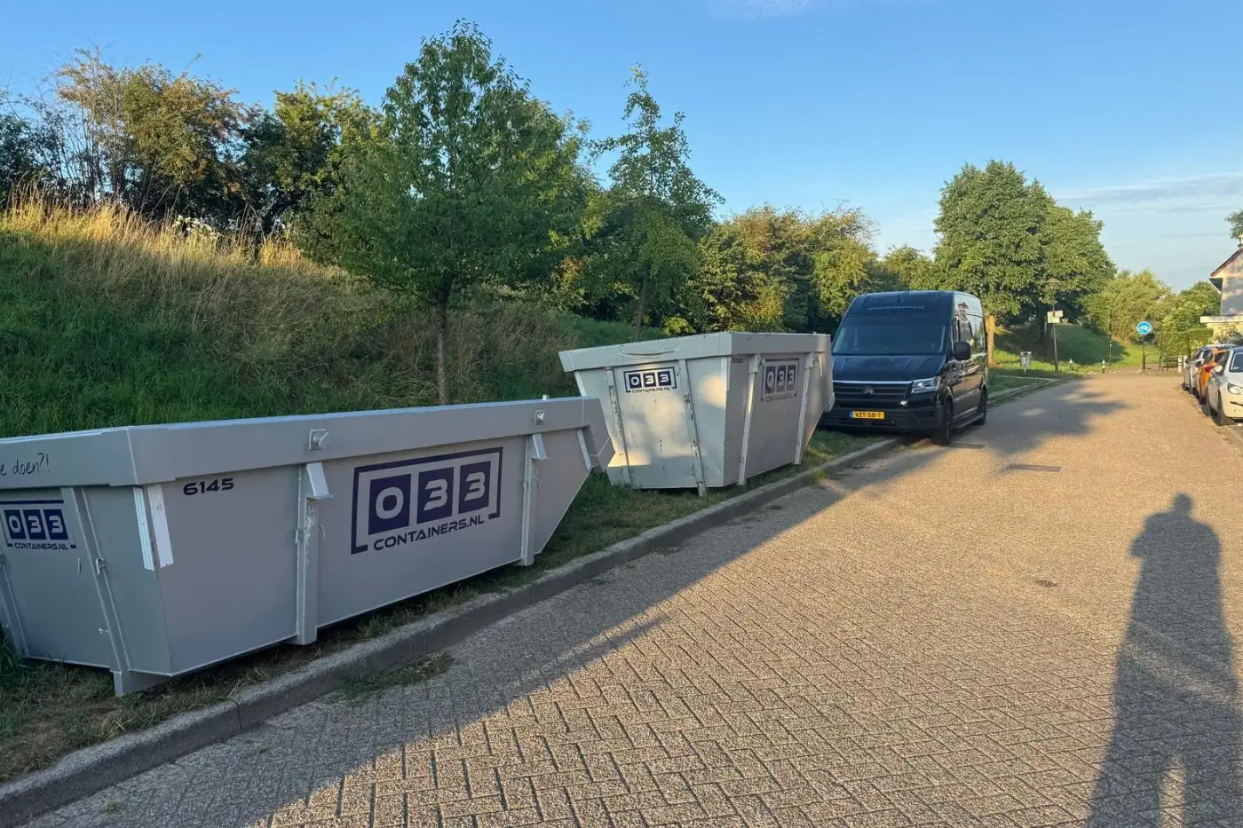 Twee afvalcontainers van 033 Containers langs de weg bij een tuinproject in de regio Amersfoort